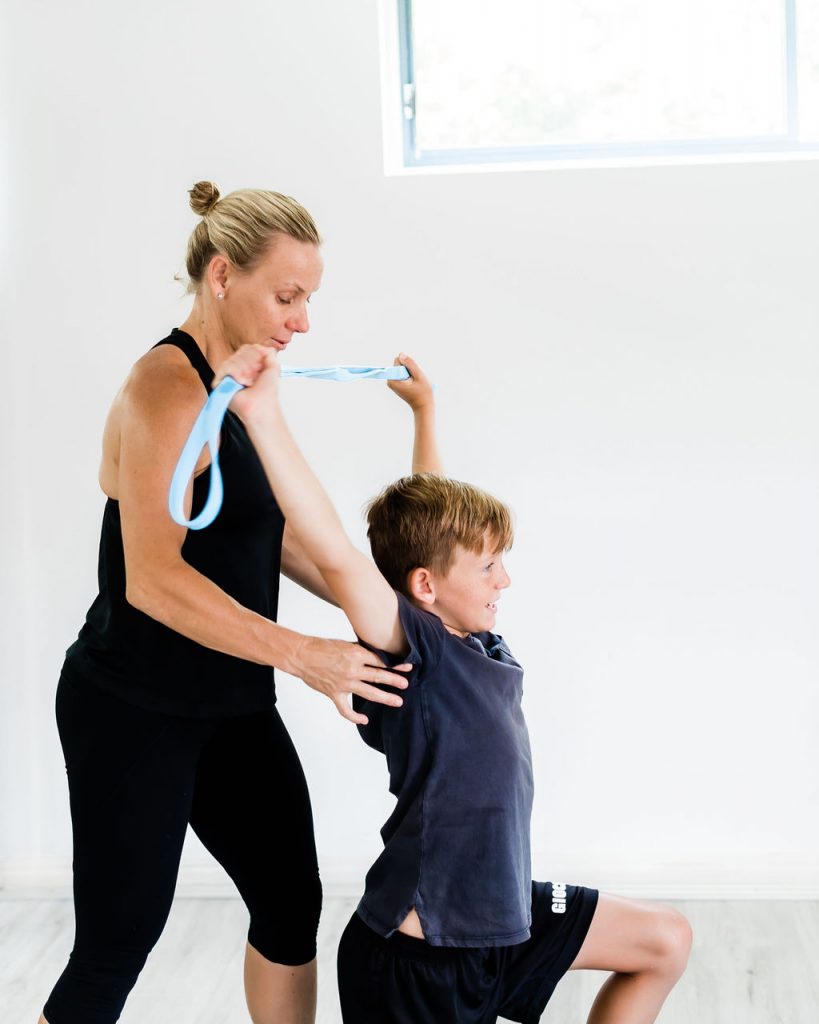 instructor helping young boy stretch