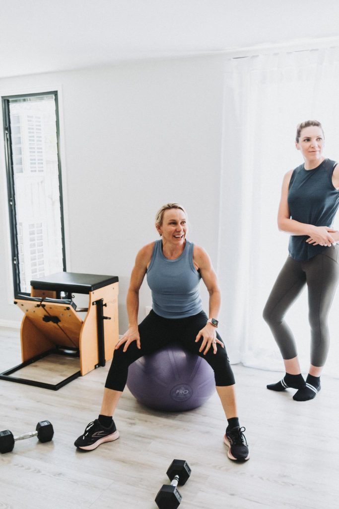 studio fitness instructor on a large ball